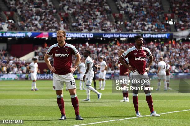Craig Dawson and Ben Johnson of West Ham United react after play is stopped due to a crowd incident during the Premier League match between West Ham...