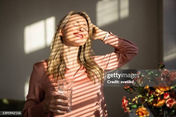 attractive mature blond woman - interiors with plants and sun stock pictures, royalty-free photos & images