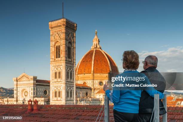 senior couple looking at the duomo, florence, italy - campanário florença imagens e fotografias de stock