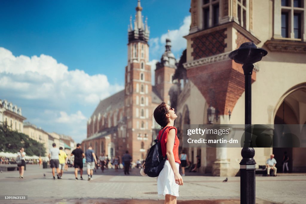 Tourist woman enjoying sprinkler in hot day