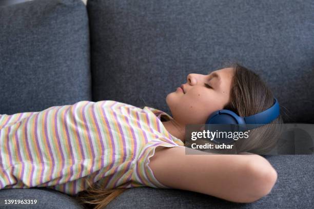 teenage girl  in headset listen to audiobook with closed eyes - child eyes closed stock pictures, royalty-free photos & images