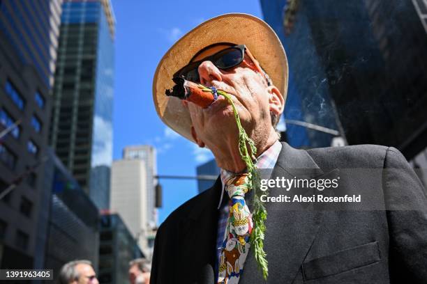 Wayne Darr smokes a cigar that looks like a carrot at the annual Easter Parade and Bonnet Festival along Fifth Avenue on Easter Sunday on April 17,...