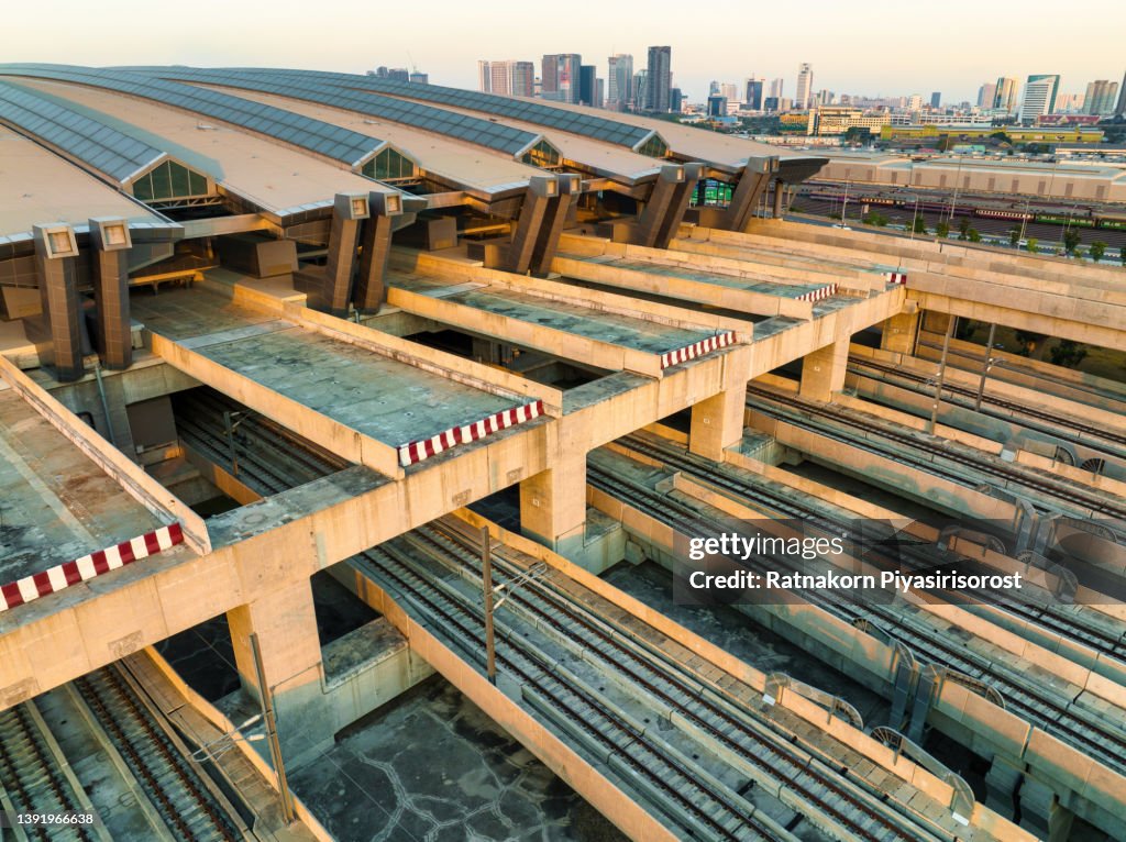 Aerial drone view of train rail tracks, electricity cables and station platform at Bang Sue central station, the new railway hub transportation building under construction in Bangkok, Thailand
