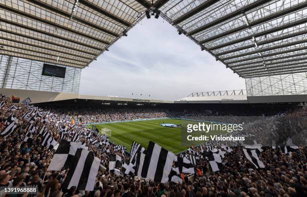 Newcastle United fans wave flags bbefore the Premier League match between Newcastle United and Leicester City at St. James Park on April 17, 2022 in...