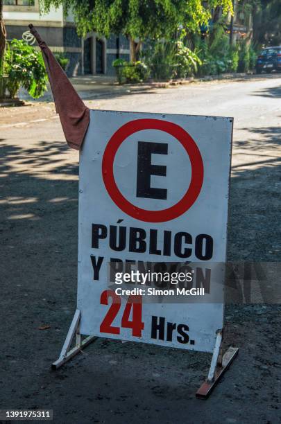 spanish-language freestanding portable sign stating 'estacionamiento público y pensión 24 hrs' [public parking and boarding 24 hours] in a city street - temporary hours stock pictures, royalty-free photos & images