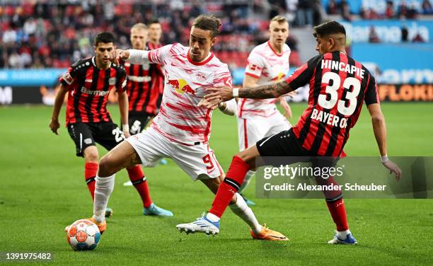 Yussuf Poulsen of RB Leipzig is challenged by Piero Hincapie of Bayer 04 Leverkusen during the Bundesliga match between Bayer 04 Leverkusen and RB...