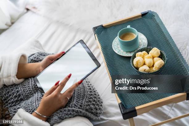 woman using tablet during breakfast in bed. - pão de queijo stock pictures, royalty-free photos & images