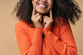 Happy African American woman pointing finger on white teeth isolated on background. Health care, dental treatment concept