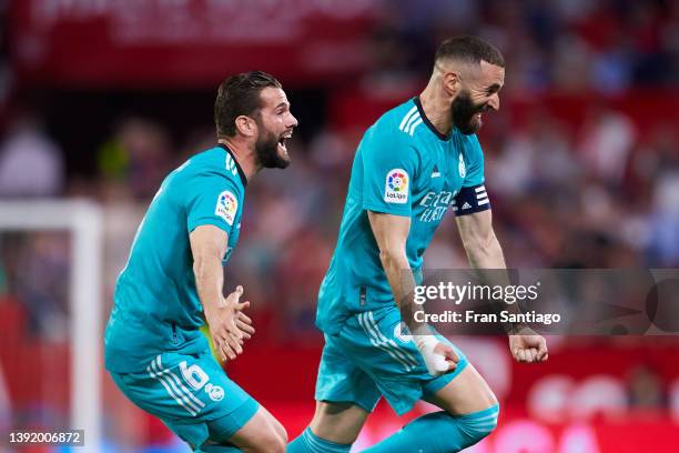Karim Benzema of Real Madrid celebrates scoring his teams second goal with team mates during the LaLiga Santander match between Sevilla FC and Real...