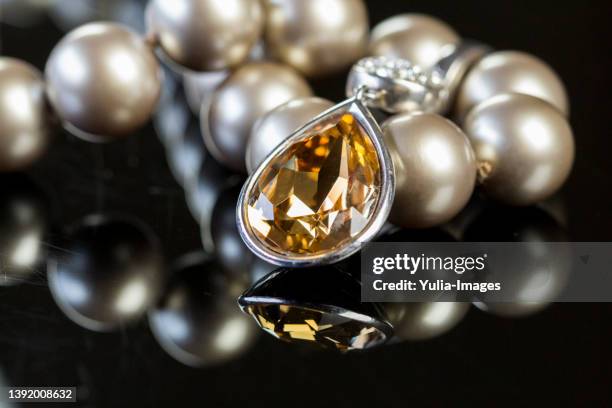 elegant pearl necklace on glossy table - pearl necklace stockfoto's en -beelden