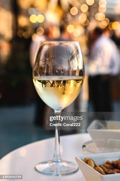 glass of white wine on the table at a celebratory event - glass half full party stock pictures, royalty-free photos & images