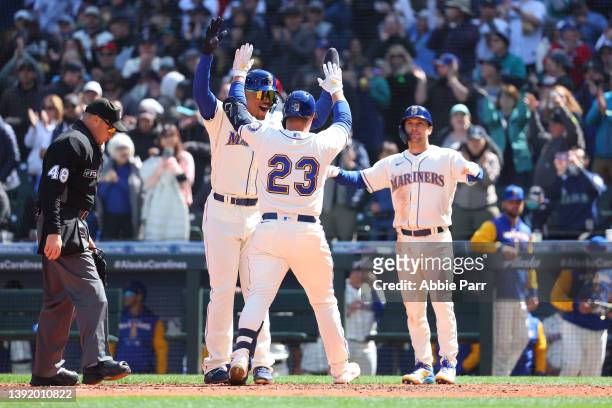 Ty France of the Seattle Mariners celebrates with Julio Rodriguez and Adam Frazier after hitting a three-run home run against the Houston Astros...