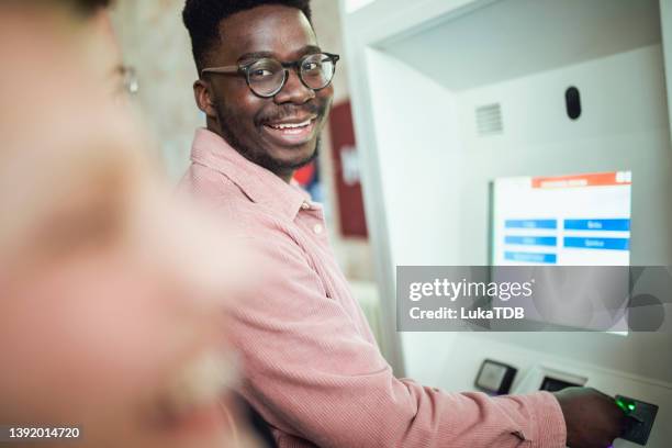 a smiling tourist checks a ticket before traveling. - commuter train stock pictures, royalty-free photos & images