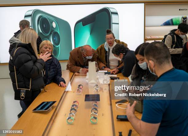 Sales people advise customers as they look at Apple Watches at the World Trade Center Apple Store on April 17, 2022 in New York City.