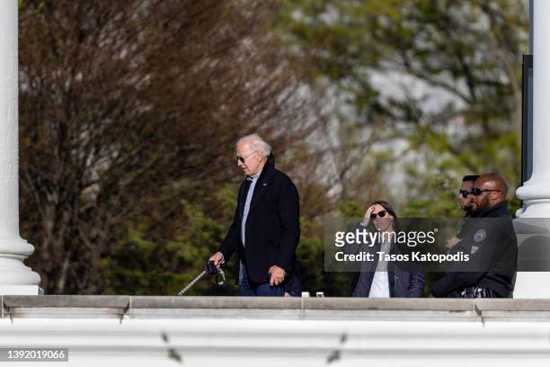 President Joe Biden walks Ashely Biden's dog into the White House, after his motorcade dropped him off on the north lawn, on April 17, 2022 in...