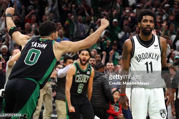 Jayson Tatum of the Boston Celtics celebrates the game winning basket as Kyrie Irving of the Brooklyn Nets looks on during the fourth quarter of...