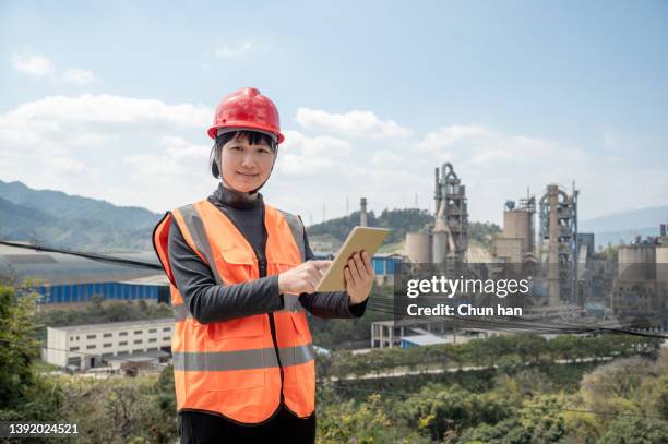 a female worker observed the data with a flat plate in front of the cement plant - fleet manager stock pictures, royalty-free photos & images