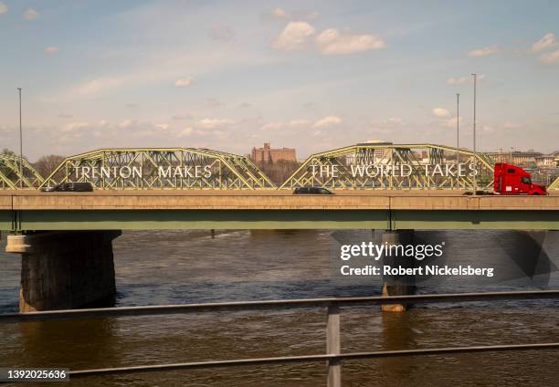 Car and commercial trucks cross a bridge April 14, 2022 over the Delaware River in Trenton, New Jersey.