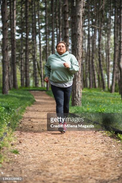 overweight hispanic woman running in a forest - morbidly obese woman 個照片及圖片檔