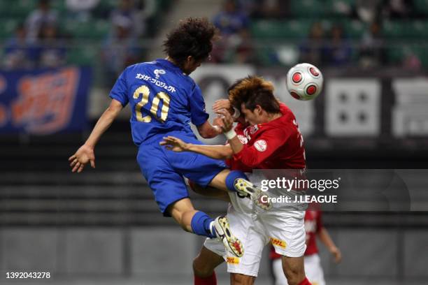 Daisuke Takahashi of Oita Trinita competes for the ball against Satoshi Horinouchi and Hajime Hosogai of Urawa Red Diamonds during the J.League...