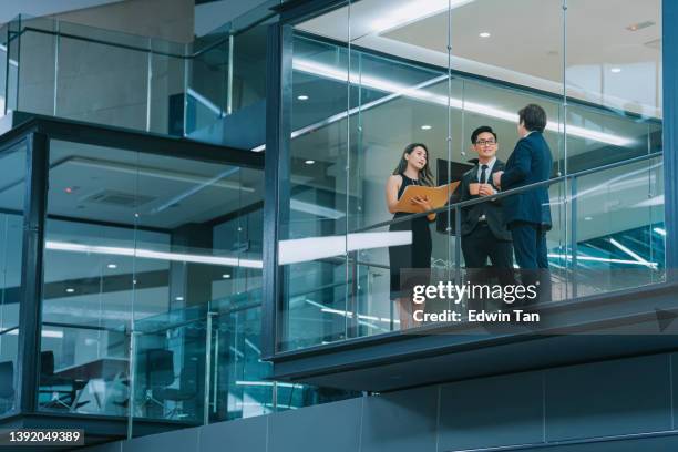 bürogebäude außenansicht durch das fenster chinesischer geschäftsmann, der spät in der nacht im besprechungsraum arbeitet - großunternehmen stock-fotos und bilder