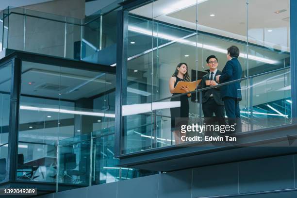 窓から覗くオフィスビル外観 深夜に会議室で働いている中国人ビジネスパーソン会議 - corporate business ストックフォトと画像