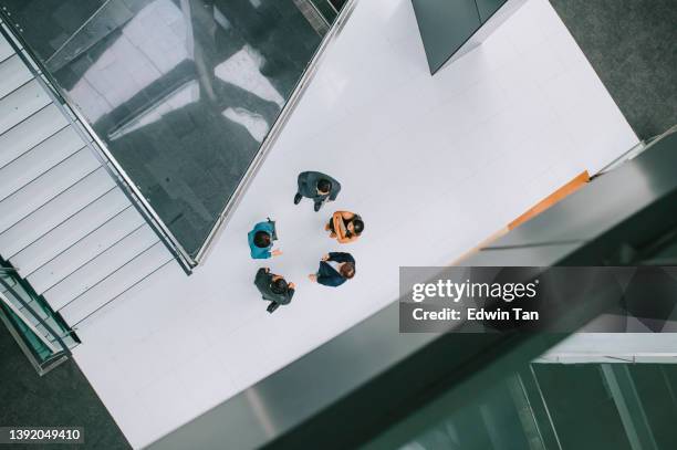 colega de ropa de negocios chino asiático hablando en el pasillo en el edificio de oficinas después del trabajo - the bigger picture fotografías e imágenes de stock