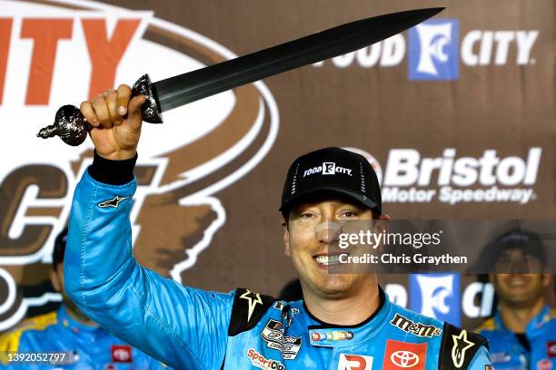 Kyle Busch, driver of the Mars Crunchy Cookie Toyota, celebrates in victory lane after winning the NASCAR Cup Series Food City Dirt Race at Bristol...