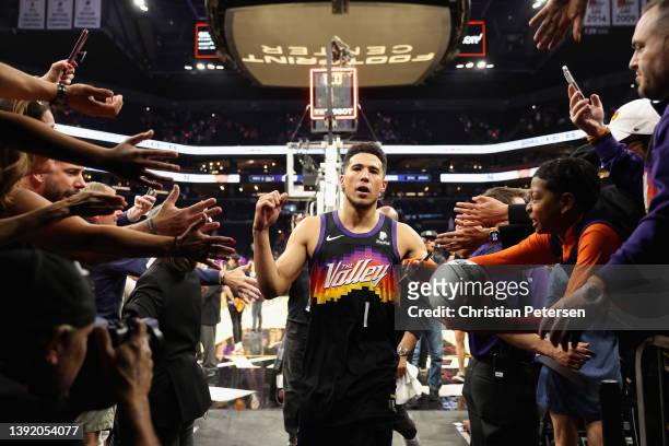 Devin Booker of the Phoenix Suns high fives fans as he walks off the court following game one of the Western Conference First Round NBA Playoffs...