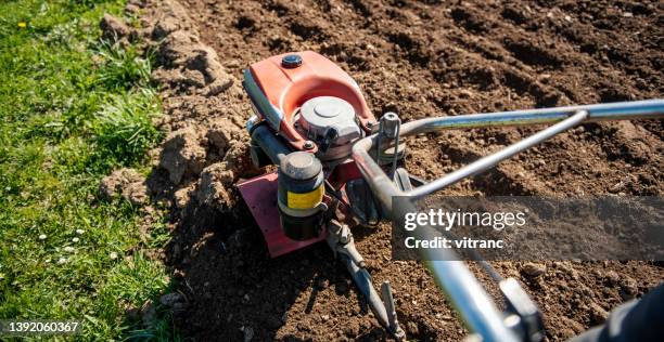 agricultor que trabaja en el jardín con garden tiller - harrow fotografías e imágenes de stock