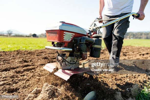 farmer working in the garden with garden tiller - harrow agricultural equipment stock pictures, royalty-free photos & images