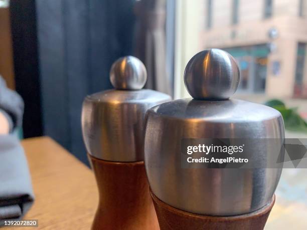 a couple of salt shakers look longingly at the street. - 胡椒入れ ストックフォトと画像