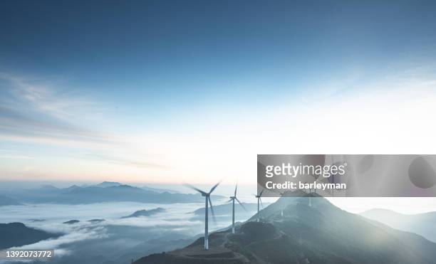 aerial view of wind turbines shrouded in clouds at sunrise - viver imagens e fotografias de stock