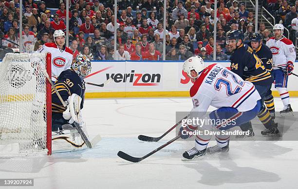 Tomas Kaberle of the Montreal Canadiens scores a first period power play goal against Ryan Miller of the Buffalo Sabres as both David Desharnais of...