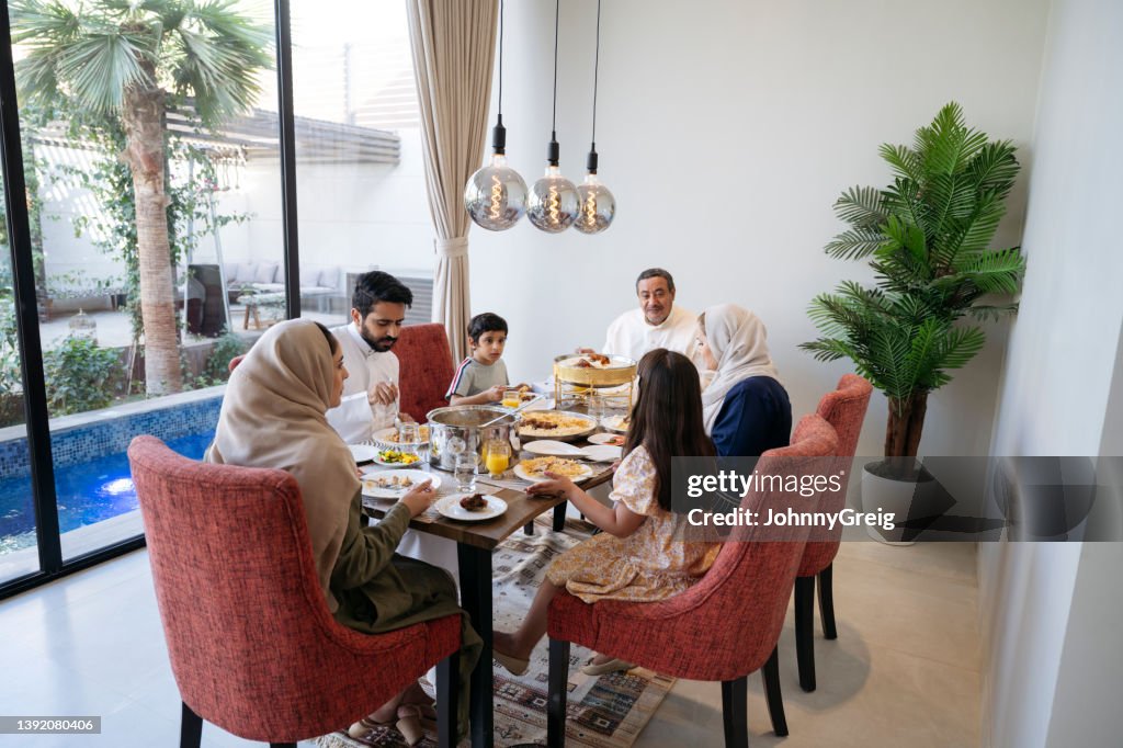 Saudi family talking and eating together in modern home
