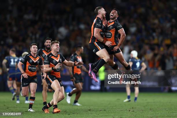 Jackson Hastings of the Tigers celebrates with team mates after kicking a field-goal to win the round six NRL match between the Parramatta Eels and...