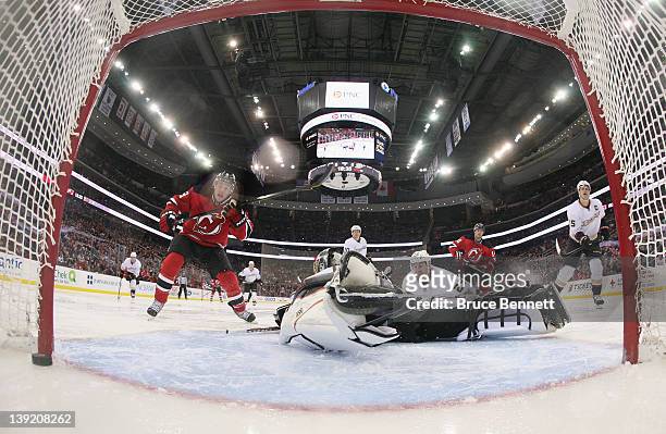 Zach Parise of the New Jersey Devils watches a shot by Adam Henrique elude goaltender Jonas Hiller of the Anaheim Ducks at 1:25 of the second period...