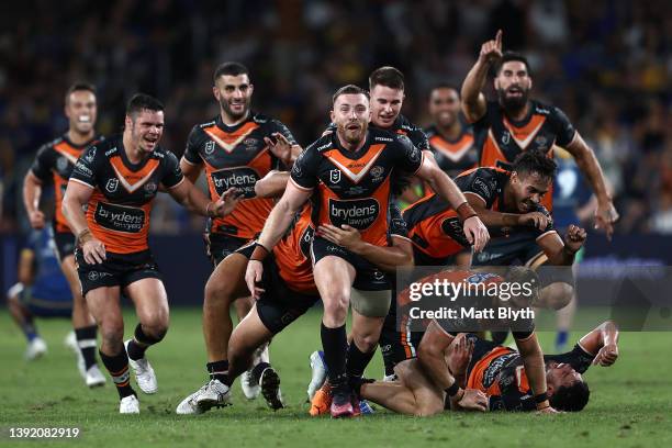 Jackson Hastings of the Tigers celebrates with team mates after kicking a field-goal to win the round six NRL match between the Parramatta Eels and...