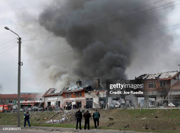 Firefighters battle a blaze after a civilian building was hit by a Russian missile on April 18, 2022 in Lviv, Ukraine. At least six people were...