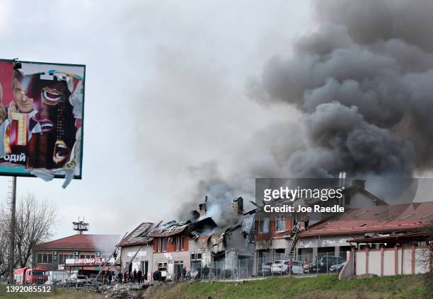 Firefighters battle a blaze after a civilian building was hit by a Russian missile on April 18, 2022 in Lviv, Ukraine. At least six people were...