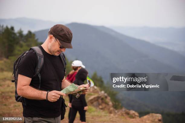man reading a map when in adventure with children - lost generation stock pictures, royalty-free photos & images