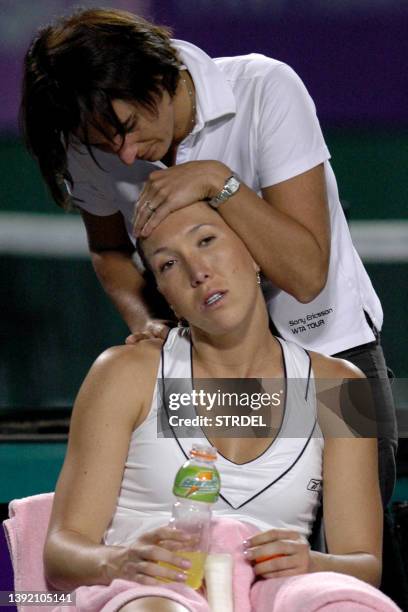 Serbian tennis player Jelena Jankovic receives treatment from a trainer during her womens singles match against Chinese opponent Yan Zi at WTA...