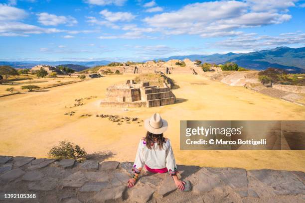 woman admiring monte alban archaeological site, oaxaca, mexico - internationaal monument stockfoto's en -beelden