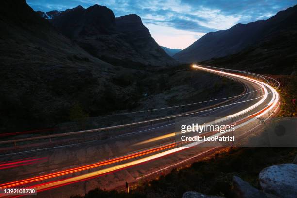 light trails left by cars at night in a country road - traffic aerial stock pictures, royalty-free photos & images