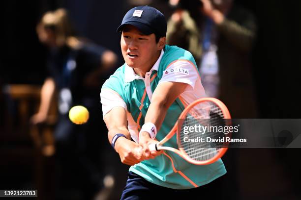 Soonwoo Kwon of South Korea plays a backhand against Benoit Paire of France during day 1 of the ATP500 Barcelona Open Banc Sabadell at Real Club De...