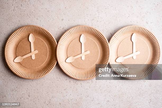 wooden spoons on a biodegradable birch wood disposable plate, top view. 16:8 intermittent fasting concept. - stoffwechsel entgiftung stock-fotos und bilder