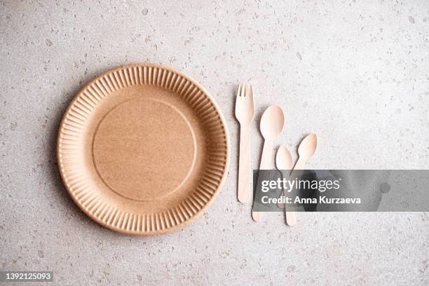 biodegradable birch wood disposable tableware and cutlery on concrete background, top view. zero waste concept. plastic free. - papieren bord stockfoto's en -beelden