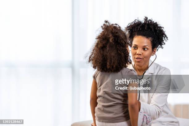 young girl is examined by female doctor - pediatric imagens e fotografias de stock