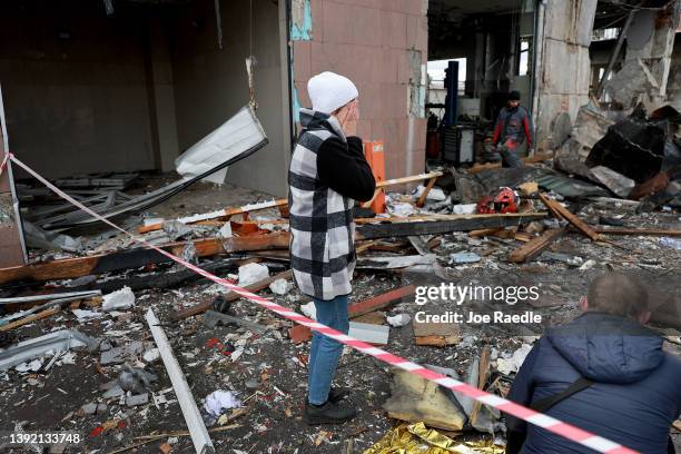 Woman reacts as she looks on at the destruction caused when a civilian building was hit by a Russian missile on April 18, 2022 in Lviv, Ukraine. At...