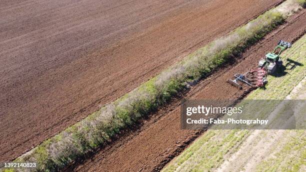 tractor plowing field - harrow stock pictures, royalty-free photos & images